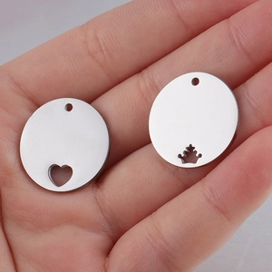 Macro detail of 20mm stainless steel round charms with heart and crown hollow designs