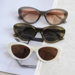 Close-up of cat-eye polarized sunglasses in grey, olive green, and cream white