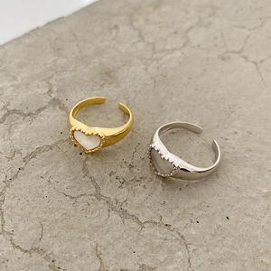 Detail of heart shell rings in gold and silver finish with beaded metal edges