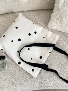 Minimalist canvas tote bag with black polka dot pattern and durable web handles