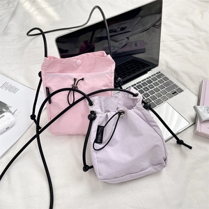 Dettaglio di borse a tracolla con coulisse rosa e viola con etichette Sozakka