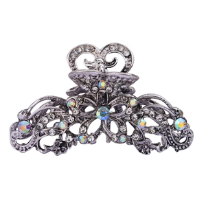 Vintage hollow silver hair claw clip with floral rhinestone design on white background