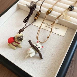 Detail of handmade pug dog and cat ceramic pendants on adjustable braided wax ropes