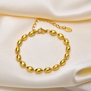 Detail of 18K gold-plated oval bead chain with lobster clasp on white satin