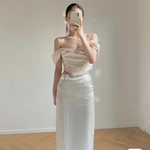 Dettaglio del top in raso con spalle scoperte e gonna lunga in champagne e bianco