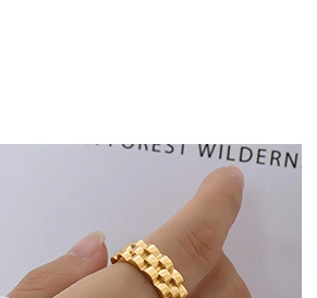 Close-up of golden triple-row watch band style ring with semi-cylindrical textures