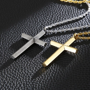 Polished silver and gold cross pendants with twist rope chains on a dark leather background
