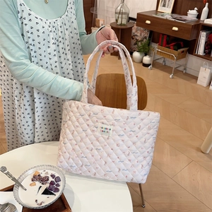 Quilted cream tote bag detail featuring cute bear prints and model hand holding display