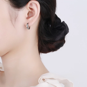 Elegant 925 silver hoop earrings with heart charms and cubic zirconia on model