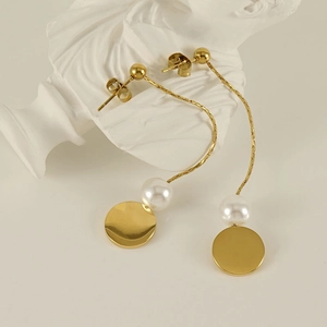 18K gold titanium steel tassel earrings with white pearls on a white mannequin bust