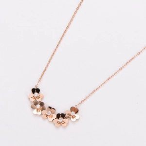 Detail of rose gold clover necklace with five small flowers inlaid with crystals