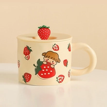 Close-up of ceramic Christmas mug featuring cartoon girl pattern and strawberry lid