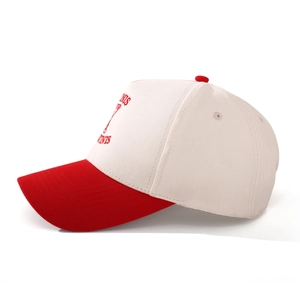 Detail of red and cream baseball cap showing martini embroidery and twill texture