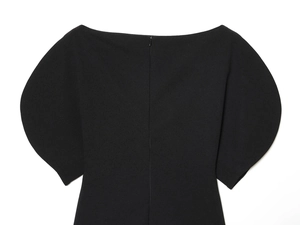 Detail of black top featuring a square neckline, puffed sleeves, and hidden back zipper