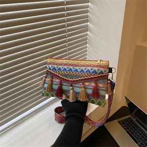 Detailed view of bohemian envelope bag with colorful geometric patterns and fringe tassels
