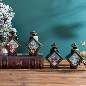 Close-up of vintage Christmas lanterns with Santa and reindeer motifs on a wooden desk