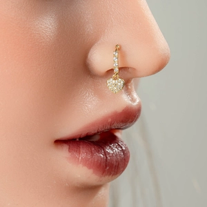 Anneau de nez doré avec pendentif cœur et pavé de zircons sur un mannequin femme
