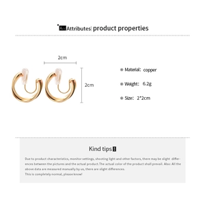 Detail view of gold circular clip-on earrings with copper material and size specifications