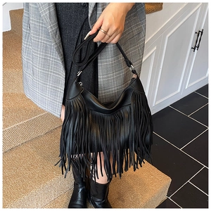 Close-up of black fringe bucket bag with silver hardware and lychee grain leather