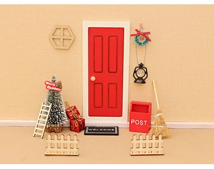 Miniature dollhouse Christmas scene with red wood door, tree, mailbox, and festive props