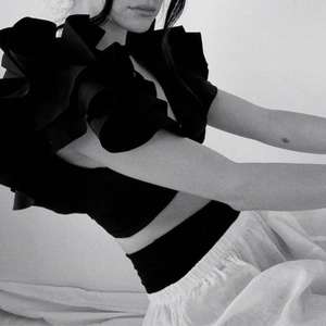 Detail shot of sculptural black ruffled shoulder bikini top with high-fashion silhouette