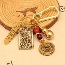 Detail of vintage brass keychain with zodiac snake relief and lucky coin pendants