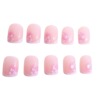 Unghie finte corte tonde con sfumatura rosa blush e decorazioni floreali bianche