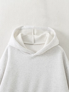 Close-up of drawstring hood and soft fleece lining on light grey knitted hoodie