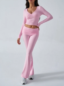 Detail of pink knitted long-sleeve V-neck crop top and matching low-rise flare pants