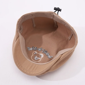 Detail of khaki cotton baby hat featuring bear embroidery and adjustable drawcord toggle