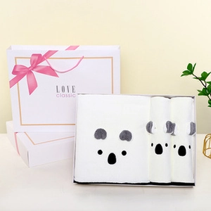 Detailed set of three white towels with cute koala embroidery in a gift box with a bag