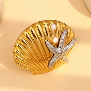 Detailed macro view of 18K gold-plated shell earrings with silver starfish and pearls