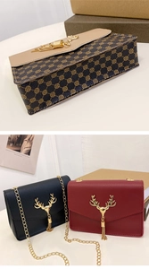Nahaufnahme der Umhängetasche mit goldenem Hirschkopf-Verschluss und Metallquaste