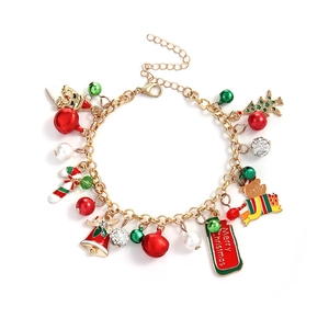 Close-up of golden Christmas bracelet with bell, Santa, and enamel charms on white background