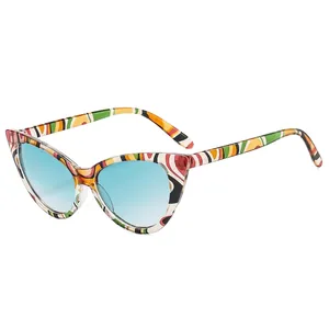 Cat eye sunglasses with multi-color abstract pattern frames and blue gradient lenses
