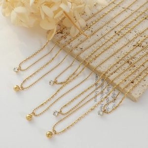 Detail of 18k gold plated stainless steel necklaces with bead and zircon pendants