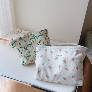 Detail of floral cotton makeup bag with zip closure and simple wish textile label