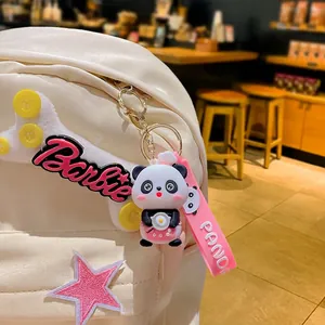 Cute panda silicone keychain charm with pink strap and Barbie bone plush on a white backpack