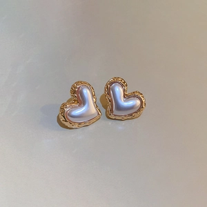 Detail of vintage gold heart earrings with lavender pearlescent texture and metal edges
