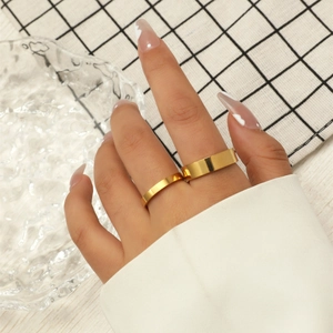 Close-up of minimalist 3mm golden titanium steel rings stacked on a model's hand
