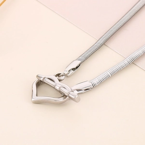 Close-up of silver snake chain necklace featuring a stylish heart-shaped OT toggle clasp