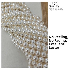 Macro view of high-gloss white glass pearl beads with smooth surface for DIY jewelry