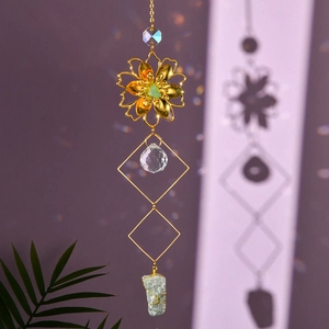 Close-up of golden flower suncatcher showing crystal ball and green natural stone