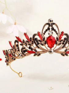 Gros plan d'une couronne baroque vintage avec cristaux rouges et strass noirs sur or