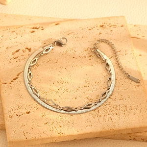 Détail du bracelet double couche argenté avec chaîne serpent, breloque losange et fermoir mousqueton