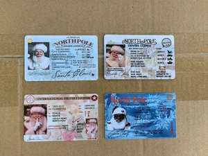 Macro shot of four plastic Santa Claus North Pole flying licenses for kids' Christmas