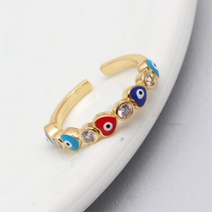 Close-up of golden adjustable ring with colorful heart-shaped evil eyes and zircon stones
