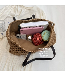 Close-up of spacious brown straw tote bag showing interior storage and zipper closure