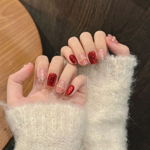 Handgemaakte rode glitter- en roze tweedpatroon kunstnagels gedragen op de handen