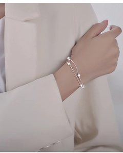 Close-up of double-layer silver star bracelet with frosted beads on woman's wrist